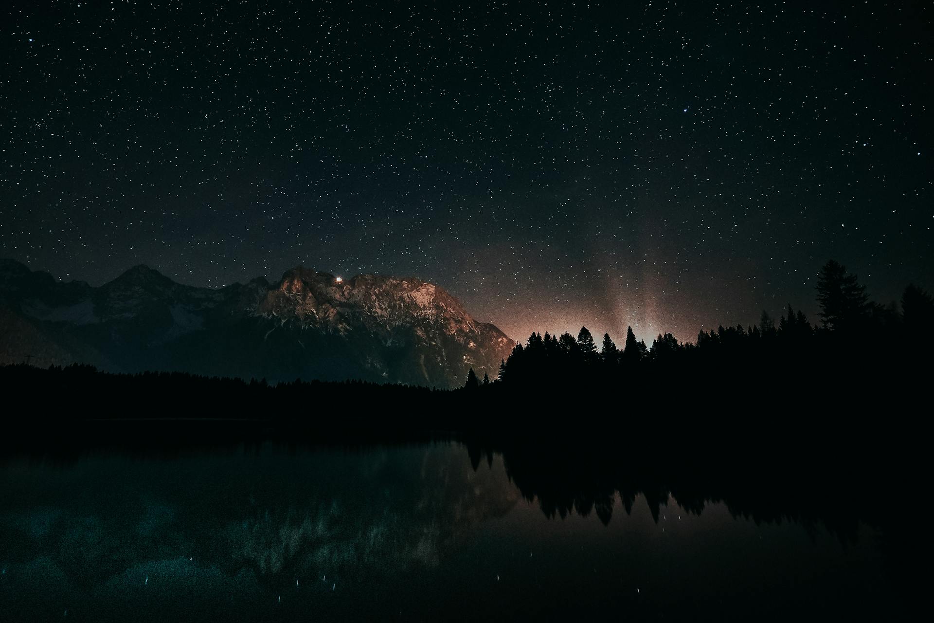 A starry night sky over a calm landscape